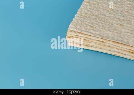 La matzah juive traditionnelle pour la fête de la pâque se trouve sur un fond bleu dans le coin supérieur droit. Beaucoup d'espace libre Banque D'Images