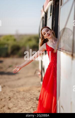 Jeune belle femme en robe rouge voyage avec le bus ou le train. . Photo de haute qualité Banque D'Images