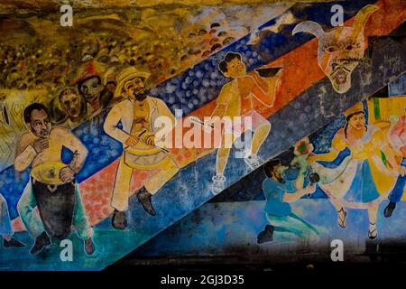 Thèmes traditionnels afro-cubains, avec des tambours colorés, peints sur un mur de maison à Santiago de Cuba, Cuba, le 2 août 2009. Banque D'Images
