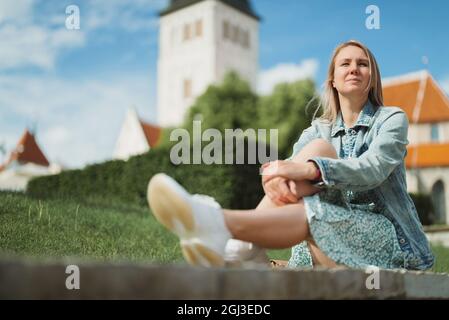 Femme se reposant contre l'église dans le vieux Tallinn. Banque D'Images