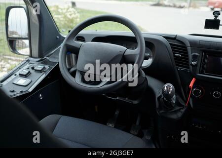 Vue rapprochée du siège conducteur, du tableau de bord du bus et du volant, vue par le pare-brise Banque D'Images