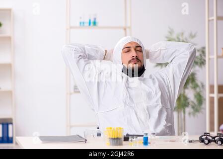 Jeune chimiste travaillant au laboratoire pendant une pandémie Banque D'Images