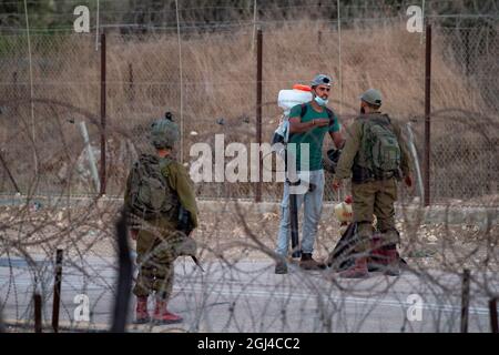 Jénine. 8 septembre 2021. Un palestinien est contrôlé par des soldats israéliens près de la ville de Jénine, en Cisjordanie, le 8 septembre 2021. L'armée israélienne a déclaré mercredi qu'elle prolontait la fermeture sur la Cisjordanie et la bande de Gaza en raison d'une chasse à l'homme pour six évadés palestiniens qui se sont enfuis lundi en s'en sortant de prison. Credit: Gil Eliyahu /JINI via Xinhua/Alamy Live News Banque D'Images