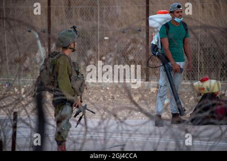 Jénine. 8 septembre 2021. Un palestinien est contrôlé par des soldats israéliens près de la ville de Jénine, en Cisjordanie, le 8 septembre 2021. L'armée israélienne a déclaré mercredi qu'elle prolontait la fermeture sur la Cisjordanie et la bande de Gaza en raison d'une chasse à l'homme pour six évadés palestiniens qui se sont enfuis lundi en s'en sortant de prison. Credit: Gil Eliyahu /JINI via Xinhua/Alamy Live News Banque D'Images