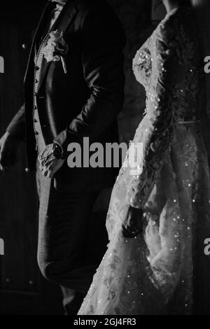 Photo en niveaux de gris de la mariée et du marié dans leur élégante tenue de mariage Banque D'Images