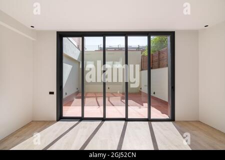 Ombres sur le sol de la lumière du soleil par de grandes fenêtres. Cette nouvelle chambre dispose de parquet dans un appartement rénové. Banque D'Images