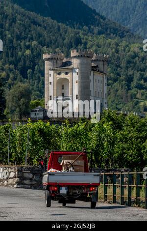 Un véhicule à trois roues se déplace le long d'une route de campagne près du château d'Aymavilles, dans la vallée d'Aoste, en Italie Banque D'Images