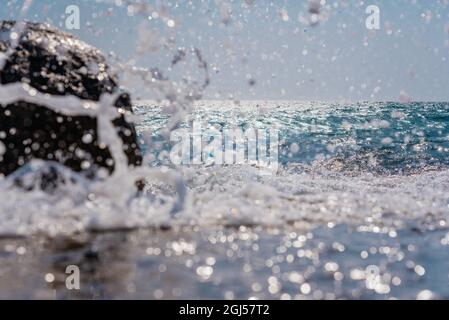 Une grosse vague de mer se décompose en mousse blanche sur le rivage, une grande vague de crasse sur le rocher de gros plan Banque D'Images