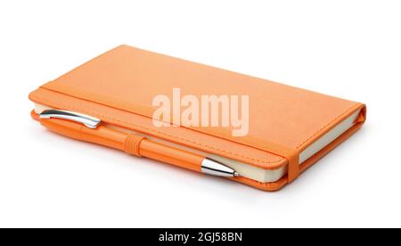 Carnet en cuir orange et stylo à bille isolés sur blanc Banque D'Images