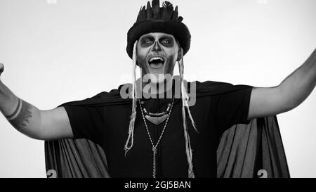 Joyeux homme créepy avec maquillage squelette célébrant la victoire, se réjouissant émotionnellement dans le succès de la victoire Banque D'Images