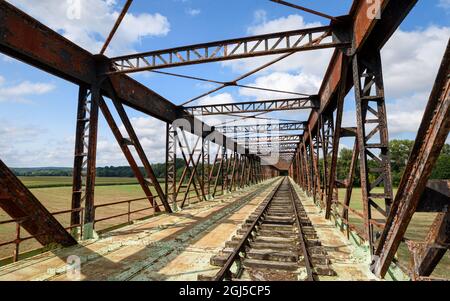 Ancienne ligne de chemin de fer traversant un pont rouillé transformé en voie de plaisance pour le train-cycle draisine avec quatre roues. Banque D'Images