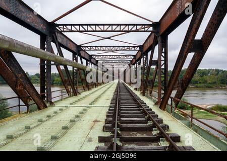 Ancienne ligne de chemin de fer traversant un pont rouillé transformé en voie de plaisance pour le train-cycle draisine avec quatre roues. Banque D'Images