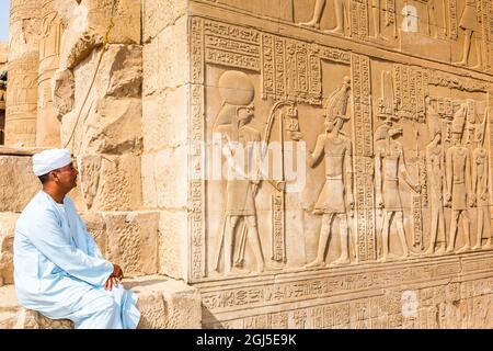 Égypte. Temple de Kom Ombo. Homme en robe de vêtements traditionnels appelé jellabiya parmi les ruines. (Usage éditorial uniquement) Banque D'Images