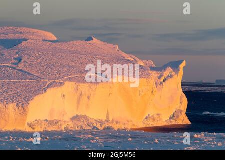 Antarctique, Snow Hill. La lumière du matin se reflète sur la glace avec une lueur orange. Banque D'Images