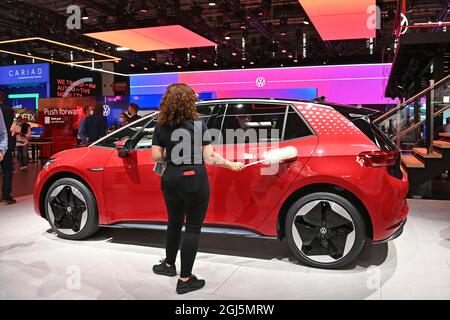 Munich. 12 septembre 2021. Stand d'exposition de Volkswagen, VW. UN ID VW. 4 est nettoyée par une jeune femme avec un plumeau. Exposition IAA Mobility du 7 au 12 septembre 2021 à Munich. Credit: dpa/Alay Live News Banque D'Images