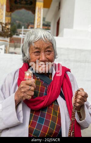 Bhoutan, Thimphu, National Memorial Chorten, alias Thimphu Stupa. Vieille femme en tenue traditionnelle avec roue de prière. (Usage éditorial uniquement) Banque D'Images