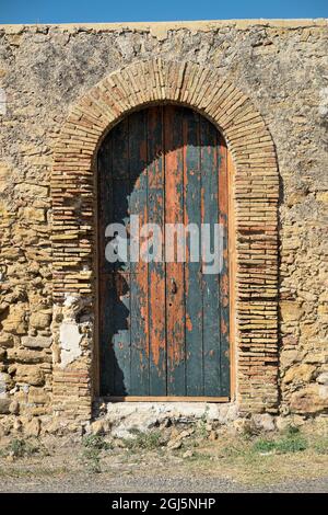 Entrée voûtée en brique rouge avec ancienne porte verte peinte de l'architecture rurale de la Sicile Banque D'Images