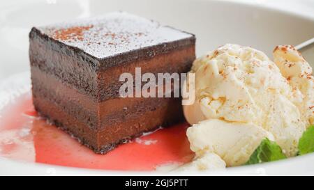 Gâteau au chocolat maison avec glace à la vanille et sauce à la framboise en gros plan. Photo de haute qualité Banque D'Images