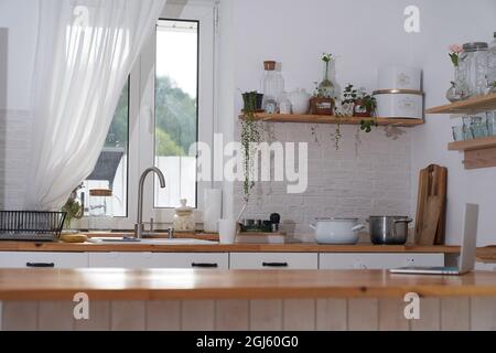 Superbe intérieur de cuisine de luxe dans la couleur blanche avec une île de cuisine en bois. Photo de haute qualité Banque D'Images