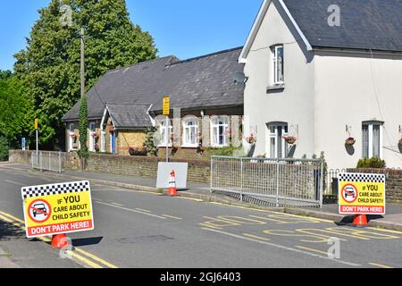 Les restrictions de stationnement dans la rue du village à l'extérieur de la porte d'entrée de l'école primaire ne sont pas assez d'affiches de sécurité routière pour enfants en usage à Kelvedon Hatch Essex, Angleterre Banque D'Images