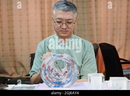 (210909) -- HENGSHUI, 9 septembre 2021 (Xinhua) -- Wang Ziyong crée des travaux de peinture intérieure sur la surface intérieure d'une bouteille dans un musée présentant des peintures intérieures dans le district de Taocheng de la ville de Hengshui, province de Hebei, dans le nord de la Chine, le 4 septembre 2021. La peinture intérieure, ou peinture intérieure, est une forme traditionnelle d'art chinois. Il s'agit à l'origine de minuscules bouteilles de tabac à priser qui ont des images et de la calligraphie peintes sur la surface intérieure de la bouteille. Les peintures de bouteille de tabac à priser sont produites en manipulant une brosse spécialisée à travers le col de la bouteille. Le processus de peinture, qui est totalement inversé i Banque D'Images