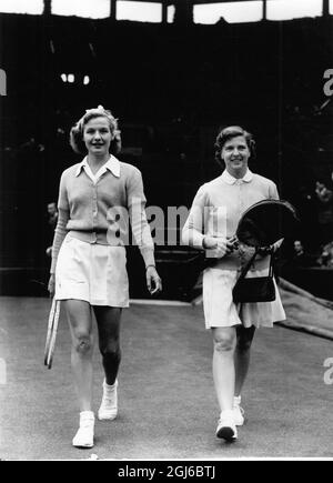 Mme A.J. Mottram (À GAUCHE, Grande-Bretagne) et Mme W. du Pont (à droite, États-Unis) marchent jusqu'à Center court à Wimbledon pour leur premier match des dames célibataires. Mme du Pont a gagné 6-3, 6-4. La pièce a été maintenue pendant plusieurs heures par la pluie. 26 juin 1951 Banque D'Images