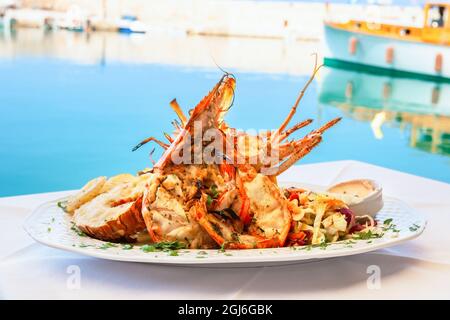 Un plat traditionnel de homard est servi à la taverne en bord de mer de Rethymno. Crète, Grèce Banque D'Images