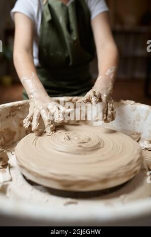 Un petit enfant travaille sur la roue de potter en atelier Banque D'Images