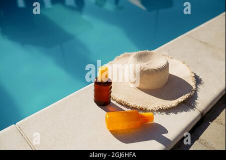 Boissons en verre et chapeau au bord de la piscine Banque D'Images