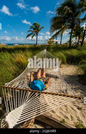 Relaxing in hammock on Grace Bay Beach, Providenciales, Turks et Caicos, Caraïbes. (MR) Banque D'Images