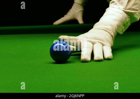 Gros plan de la table de snooker avec la main de l'arbitre sur une boule bleue. Banque D'Images