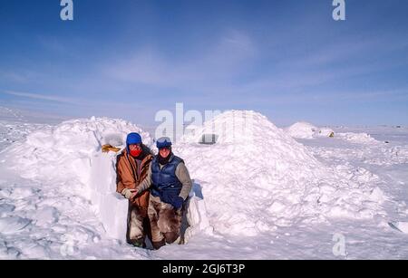 Baker Lake, Nunavut, Canada. Homme et femme à l'extérieur de l'igloo inuit construit. (M.) Banque D'Images