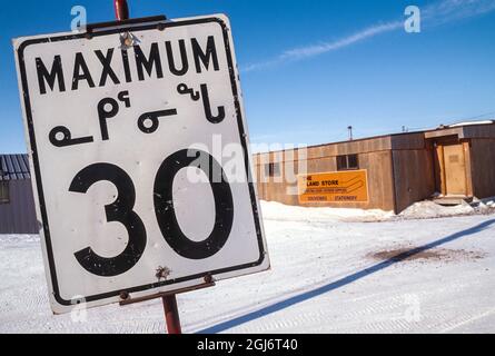 Baker Lake, Nunavut, Canada. Panneau de limite de vitesse en langue inuite (inuktitut) le long d'une rue enneigée. (Usage éditorial uniquement) Banque D'Images
