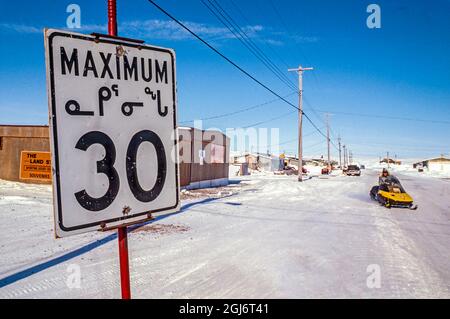 Baker Lake, Nunavut, Canada. Panneau de limite de vitesse en langue inuite (inuktitut) le long d'une rue enneigée. (Usage éditorial uniquement) Banque D'Images