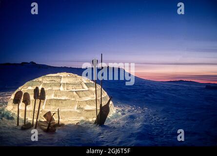 Baker Lake, Nunavut, Canada. Des outils inuits ont été détourés contre un igloo éclairé au crépuscule. Banque D'Images