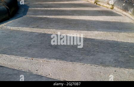 Vide chemin en béton incurvé rayé dans le jardin Banque D'Images