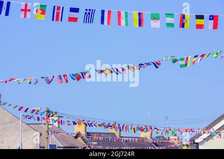 Bunting fait à partir de drapeaux internationaux festoon le village de Strangford, County Down, Irlande du Nord, Royaume-Uni, Royaume-Uni. Banque D'Images