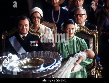 DOSSIER DE STOCKHOLM 1977-09-27 la reine Silva suédoise tient la princesse Victoria lors de la cérémonie de baptême à l'église du Palais royal de Stockholm, en Suède, le 27 septembre 1977. Derrière la reine Silvia, ses parents Alice et Walther Sommerlath sont vus et à côté de son roi Carl Gustaf. On a donné à la princesse Victoria les noms de Victoria Ingrid Alice Désirée. Le gouvernement suédois change l'héritier apparent en 1980 et la princesse Victoria, première née, devient l'héritier du trône. *** Kronprinsessan Victoria döps 1977. Kung Carl Gustaf och Drottning Silvia, med Victoria på armen, sitter i kyrkan med dopfunten i förgr Banque D'Images