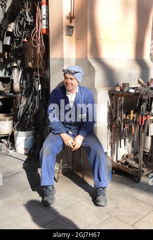 Homme se détendant à l'extérieur d'un atelier à Messine Sicile. Banque D'Images