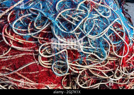 Italie, Pouilles, province de Lecce, Gallipoli. Détail de Texture de filets de pêche en rouge, blanc et bleu. Banque D'Images