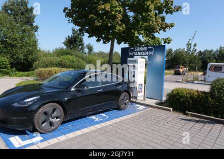 Bernau am Chiemsee, Allemagne - le 11 août 2021 : un cliché statique d'une charge de moteur double noir solide Tesla modèle 3 à la station de courant continu du supermarché ALDI Banque D'Images