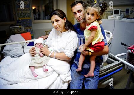 GAVLE 2013-08-04 une femme a donné naissance à un enfant dans la voiture après un accident. Samahar Mezban et sa famille étaient lourdement enceintes et se sont alors mis en route vers la maternité de l'hôpital de Gavle, mais ils n'ont pas eu cette possibilité bien avant le moment. Le mari Mokhles Raheema a regardé sa femme et a vu que l'enfant était sur le chemin qui lui a fait perdre l'attention pendant une seconde, la voiture a frappé la bande médiane retourné et a fini dans un fossé. La famille s'est échappée sans préjudice et pendant le drame Samahar a donné naissance à une fille. Sur la photo: Mère Samaher Mezban à l'hôpital de Gavle avec la fille du nouveau-né, le mari Mokhle Banque D'Images