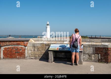 Visiteur au château de Hurst lisant un panneau d'information surplombant le phare de Hurst point sur le Solent dans le Hampshire, Angleterre, Royaume-Uni Banque D'Images