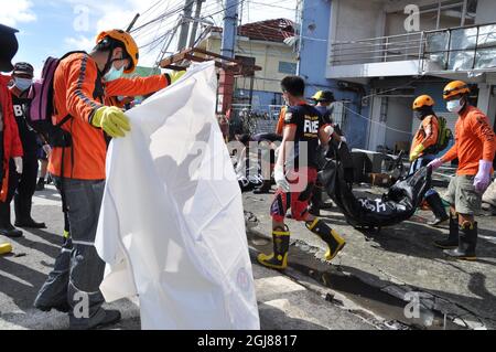 TACLOBAN 2013-11-13 : Les secouristes sont vus avec des sacs de corps dans la ville de Tacolaban, aux Philippines le 13 novembre 2013.le corps dans la rue est pris en charge d'abord, le défunt dans le bâtiment a à attendre.Tacolaban est l'une des zones qui a été dévastée par le Super Typhon Haiyan Foto: Gustav Sjoholm / TT / Kod 10510 Banque D'Images