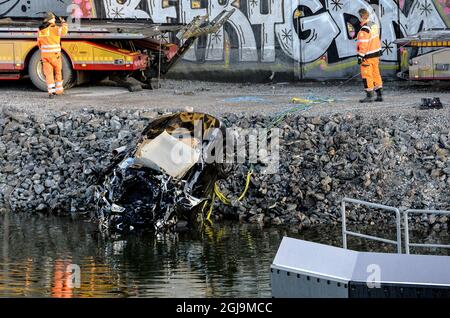 SODERTALJE 2016-02-13 Une voiture gravement endommagée est remorquée depuis le canal sous le pont autoroutier E4 à Sodertalje, en Suède, le 13 février 2016. Trois personnes ont été tuées lorsque leur voiture a traversé la porte et a décollé du pont ouvert de 29 mètres tôt samedi matin. Le pont avait été ouvert pour laisser passer un cargo sous lui et d'autres voitures s'étaient arrêtées devant la porte et les feux rouges. La raison pour laquelle la voiture en collision n'a pas pu s'arrêter est en cours d'enquête. Photo: Johan Nilsson / TT / ** SUÈDE OUT ** Banque D'Images