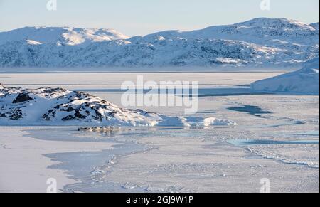 Les pêcheurs et leurs bateaux amarrés à un port de glace. Hiver au fjord Ilulissat, situé dans la baie de Disko, dans l'ouest du Groenland, le fjord fait partie du Banque D'Images