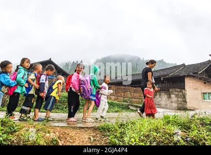 (210909) -- ZHENYUAN, 9 septembre 2021 (Xinhua) -- photo de téléphone portable prise le 7 septembre 2021 montre Zhu Muqun escortant les enfants de l'école au point d'enseignement de Pingyu du village de Songbai, canton de Baojing du comté de Zhenyuan, province de Guizhou, dans le sud-ouest de la Chine. Situé au fond de la région montagneuse du comté de Zhenyuan, de la préfecture autonome de Qiandongnan Miao et de Dong, dans la province de Guizhou, au sud-ouest de la Chine, le point d'enseignement de Pingyu est soutenu principalement par un couple. En 2000, Pan Zhongyong est diplômé d'une école normale et est venu au point d'enseignement de Pingyu en tant qu'enseignant. Plus tard, il a rencontré et épousé Zhu Muqun, Banque D'Images