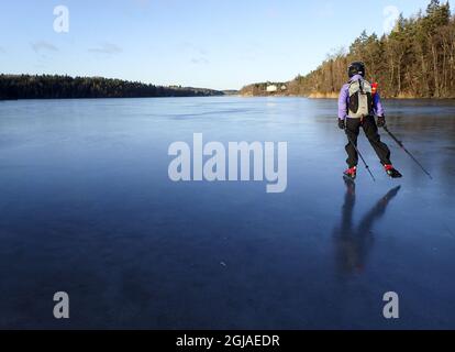 Une visite de femme skate sur le lac gelé d'Orlangen, juste au sud de Stockholm, Suède, le 23 décembre 2016. Le patinage touristique est un patinage sur glace de longue distance sur glace naturelle particulièrement populaire dans les pays nordiques. Photo: Tobias Rostlund / TT / code1014 Banque D'Images