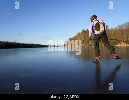 Une visite de femme skate sur le lac gelé d'Orlangen, juste au sud de Stockholm, Suède, le 23 décembre 2016. Le patinage touristique est un patinage sur glace de longue distance sur glace naturelle particulièrement populaire dans les pays nordiques. Photo: Tobias Rostlund / TT / code1014 Banque D'Images