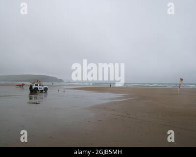 Le maître nageur RNLI en service à Bigbury on Sea pendant une journée humide et venteuse Banque D'Images